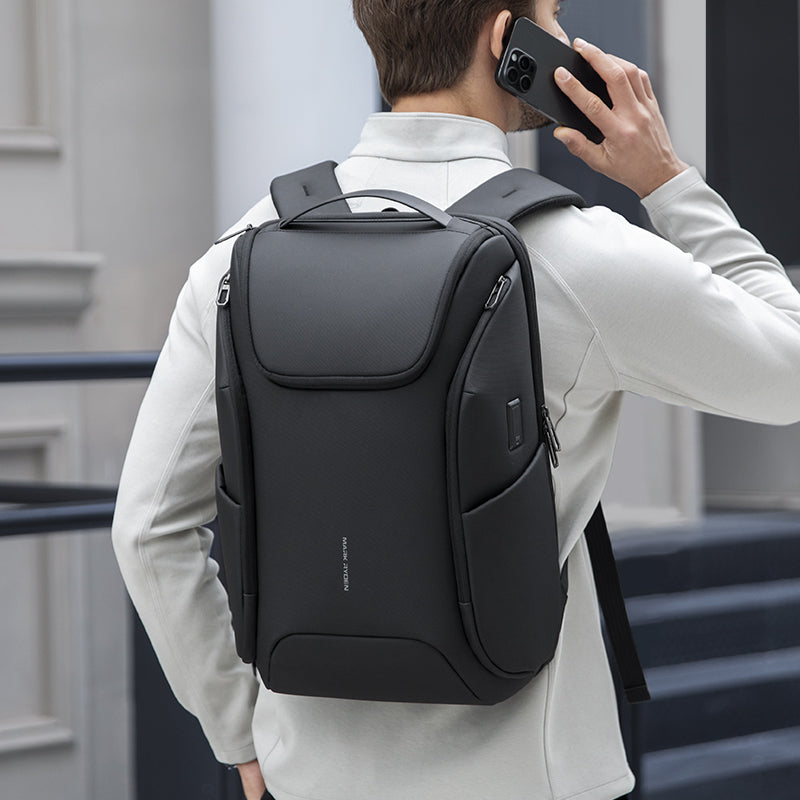 Black waterproof backpack with built-in USB, MARKRYDEN Polycom 2nd, worn by man in white jacket for travel.