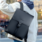 MUKE I black Oxford backpack with school style and classic business work design, featuring a flap closure and buckle, worn by a person in casual clothing.