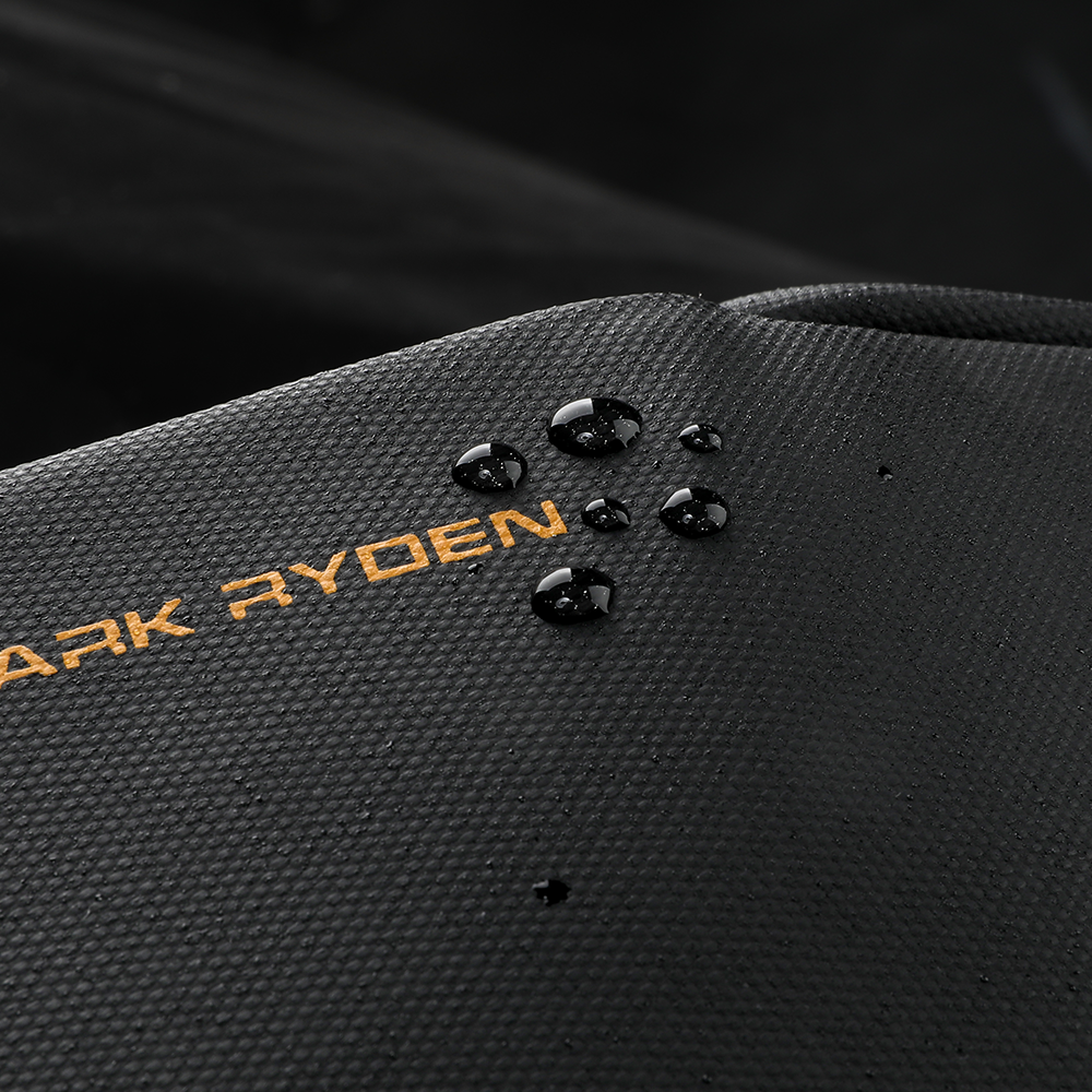 Black textured Mark Ryden backpack with orange logo, water droplets highlighting water-resistant material.