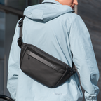 MarkRyden black waterproof crossbody bag on model in light blue jacket