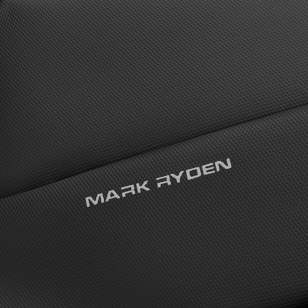 Close-up of dark gray textured leather on Mark Ryden Voyager Messenger Bag, showing embossed brand logo.