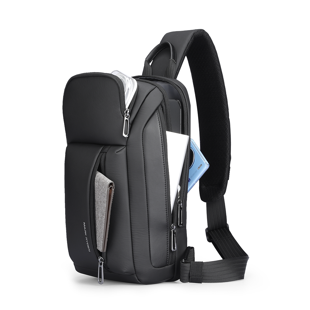 Colonne black high-capacity urban commuting crossbody bag with padded strap, multiple zippered compartments, holding blue smartphone, white tablet, gray wallet.