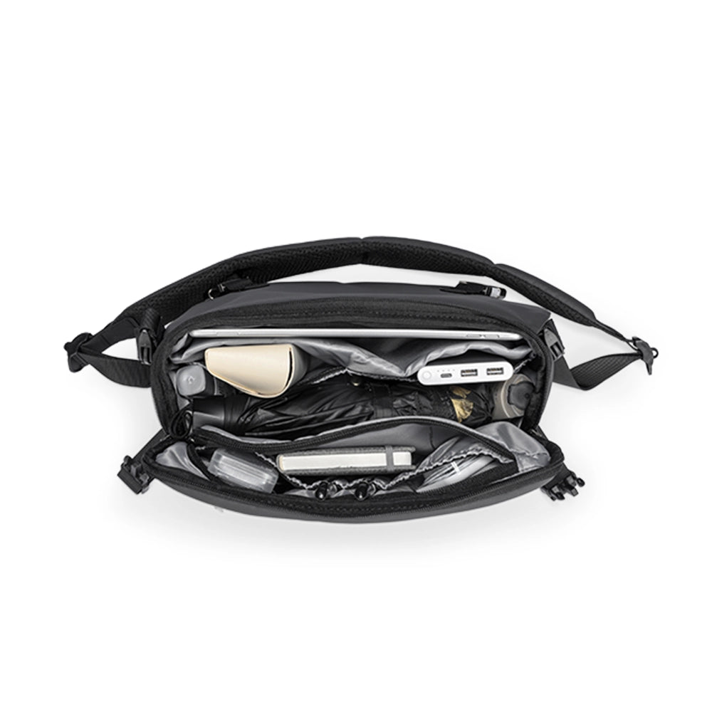 Harvey black leather waterproof multifunction messenger bag interior with gray lining, holding laptop, power bank, umbrella, and small essentials organized in compartments.