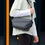 Gray Fingon anti - theft large capacity messenger bag worn by man in city - MARKRYDEN commuter bag