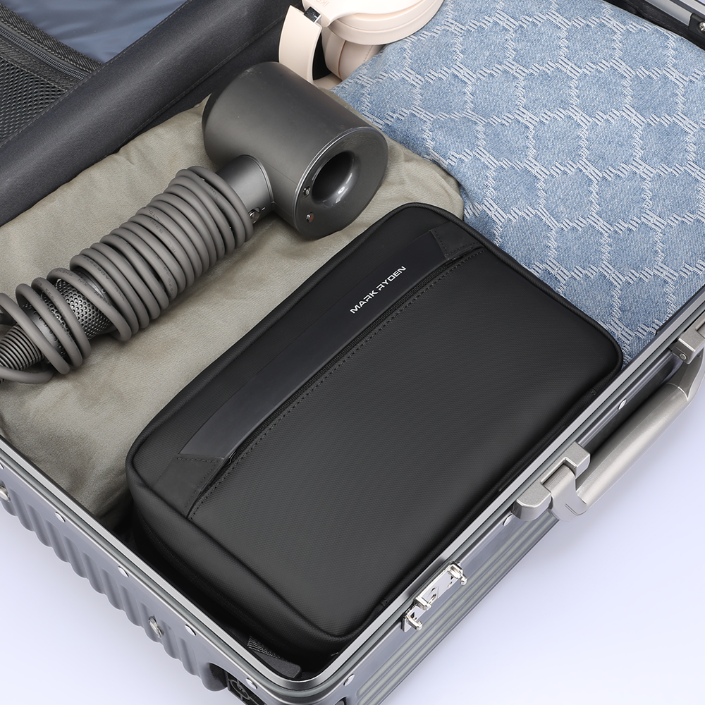 MarkRyden black compact multi-layer washbag in suitcase with travel items