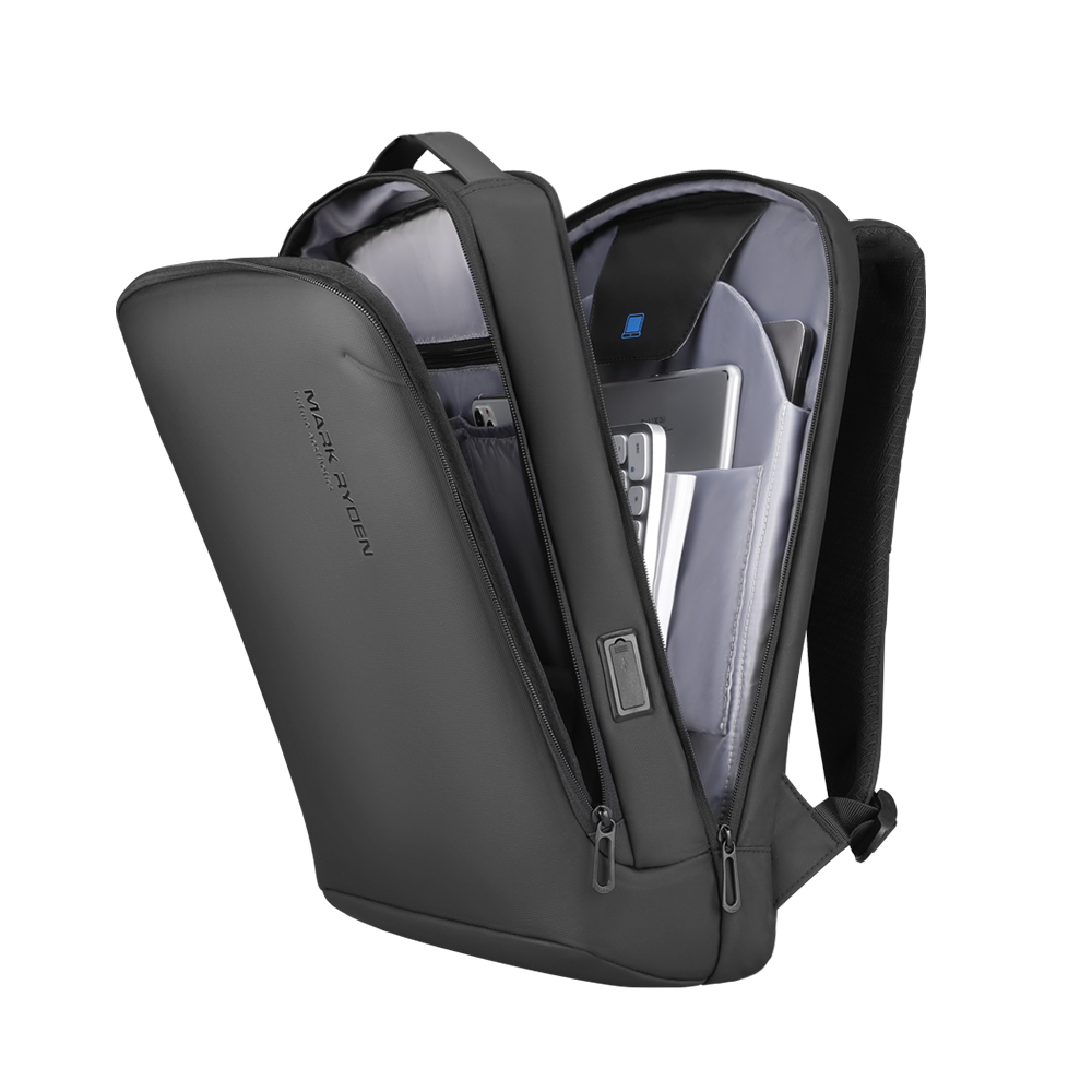 Dark gray MarkRyden futuristic minimalist lightweight backpack with open compartments holding laptop, tablet, and USB charging port.