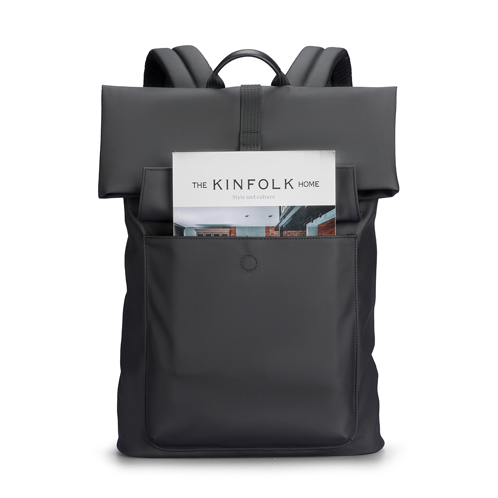 Minimalism Ⅰ dark gray roll-top backpack with front pocket holding Kinfolk Home magazine, designed for daily commute