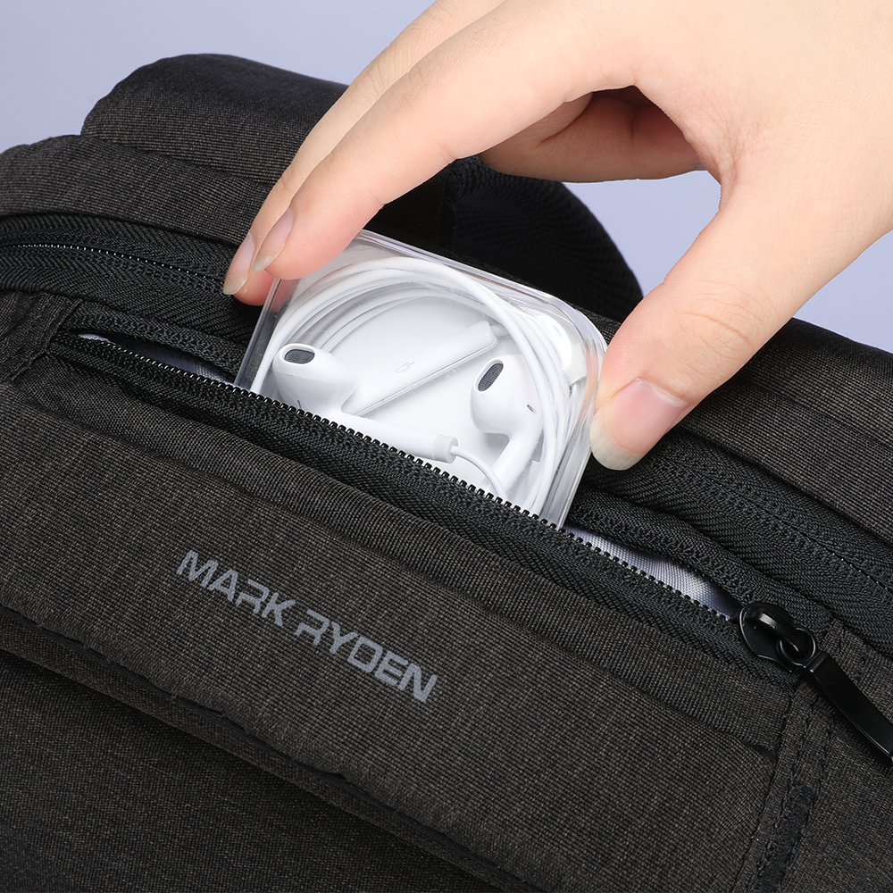 Mark Ryden black waterproof backpack with zippered pocket holding white earphones