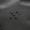 Close-up of water-repellent fabric with beading droplets on MarkRyden's multifunctional backpack, showcasing its durable, weather-resistant material for modern travels.